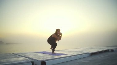 esnek kadın ince siyah giymek yapmak yoga kartal poz gündoğumu sis hızlı yavaş hareket