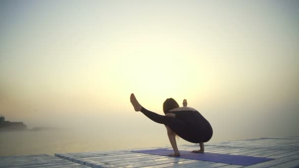 Молодая девушка стройная черная одежда сделать йогу светлячок представляет восход солнца туман быстрое замедленное движение — стоковое видео