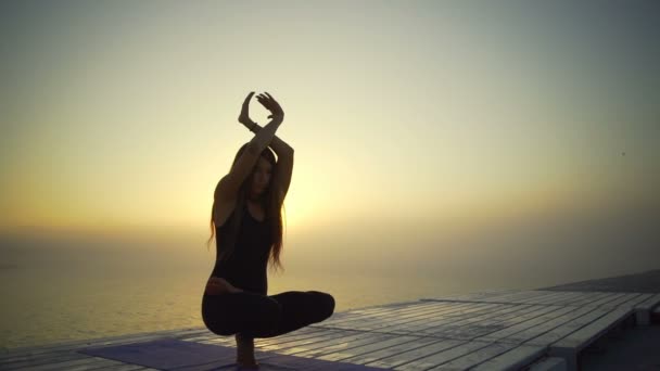 Dívka slim černé oblečení lotus meditovat jóga pozice sunrise mlha rychlý Zpomalený pohyb — Stock video