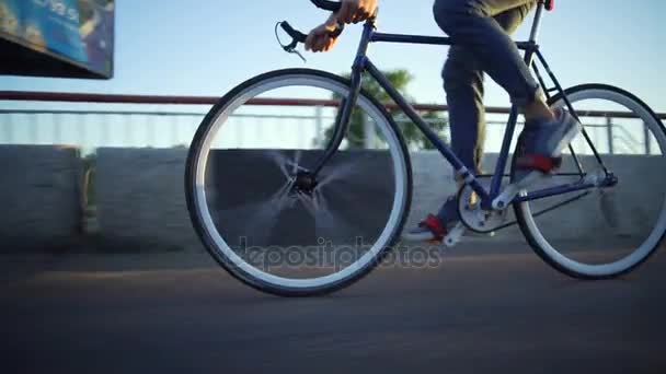 Hombre sano montando una bicicleta en la calle vacía salida del sol cámara lenta rápido — Vídeo de stock