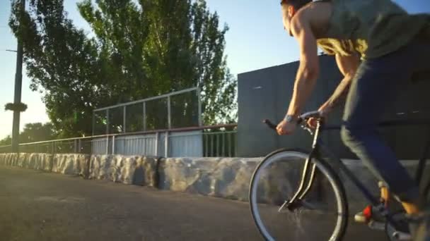 年轻人对空阳光路日出慢动作快速骑自行车 — 图库视频影像