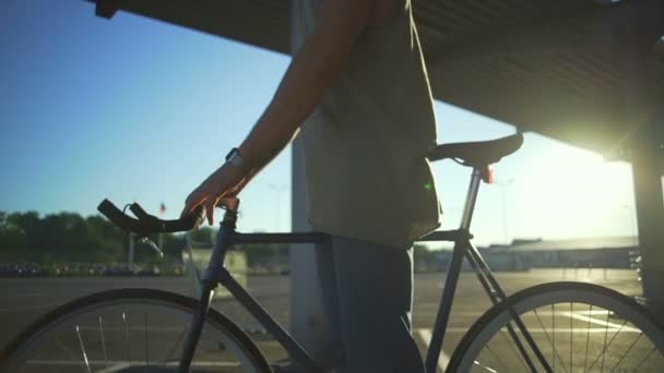 Close up ragazzo stare con la bicicletta sul parcheggio vuoto tramonto rallentatore rapido — Video Stock