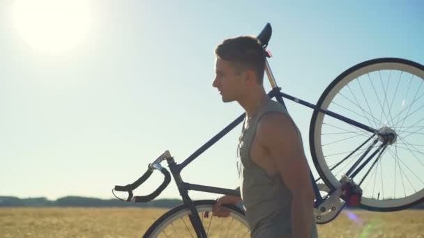 Красивый человек ходить поле с велосипедом прикосновение пшеницы заход солнца замедленное движение быстро — стоковое видео
