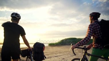 İki bisikletçiler Bisiklet sahil Haritayı şafak yavaş hareket hızlı dalgalana denize yürüyüş