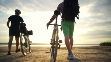 İki bisikletçiler Bisiklet zam Bisiklet sahil Haritayı şafak yavaş hareket ile hızlı yürümek