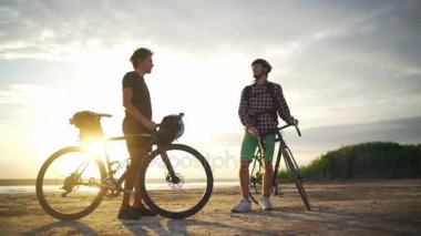 Birbirimizi yüksek beş deniz şafak yavaş hareket hızlı iki genç bisikletçiler karşılamak