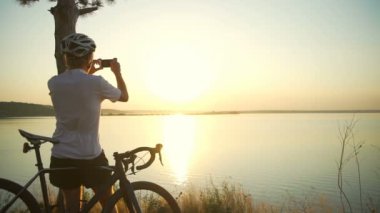 Bisikletçi standları sahil seaview bisiklet ile fotoğraf kask hızlı yavaş olun