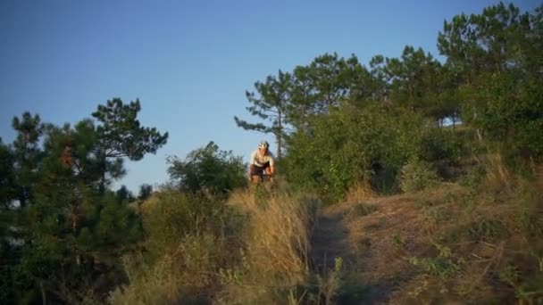 Ajuste ciclista paseo desde los arbustos de montaña puesta de sol rápida cámara lenta — Vídeos de Stock