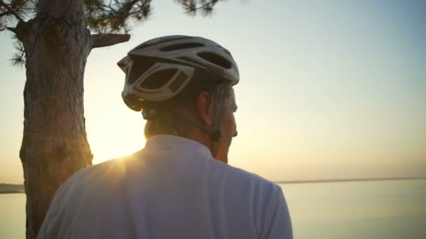 Nahaufnahme Radfahrer genießen Meerblick Sonnenaufgang Helm Baum schnelle Zeitlupe — Stockvideo