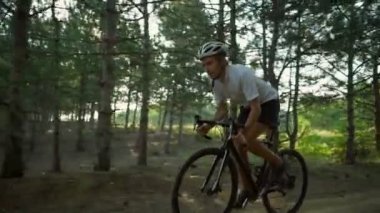 Bisikletçi binmek bisiklet güneşli orman yol gündoğumu kask hızlı yavaş hareket