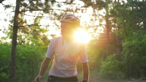 Νέος ποδηλάτης μείνετε στο δάσος με την Ανατολή του ηλίου ποδηλάτων κράνος ταχεία αργή κίνηση — Αρχείο Βίντεο