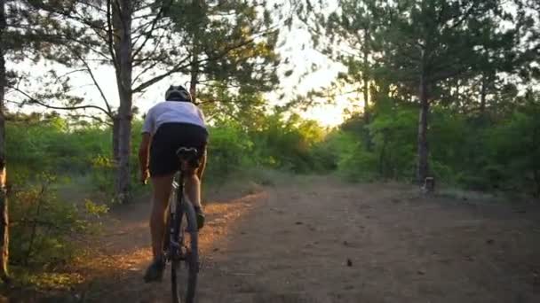 Крепкий велосипедист катается на велосипеде по лесной дороге закатного шлема быстрое замедленное движение — стоковое видео