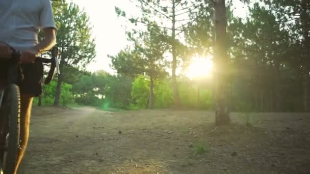 Knappe wielrenner blijven in forest met fiets zonsopgang helm snelle langzame motie — Stockvideo
