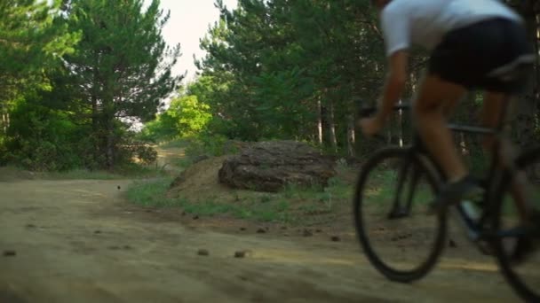 Cyklist rida cykel kurviga skog sökvägen dawn hjälm bakifrån snabba slowmotion — Stockvideo