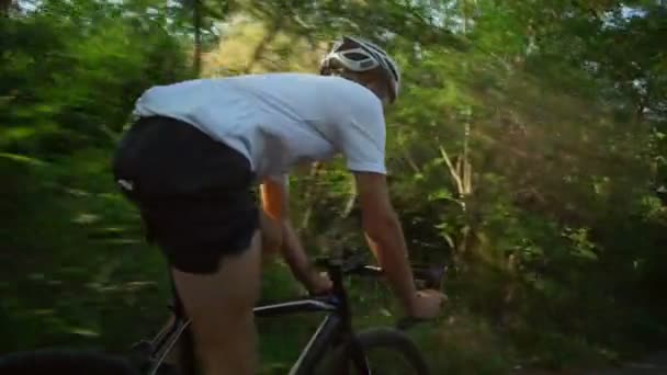 Jovem ciclista passeio de bicicleta na floresta estrada madrugada capacete rápido câmera lenta — Vídeo de Stock