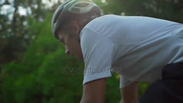 Close-up van jonge fietser rit fiets bos weg dawn helm snelle Slowmotion — Stockvideo
