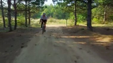 Bisikletçi binmek hızlı bisiklet güneşli orman yolu kask günbatımı dron görüntüleri