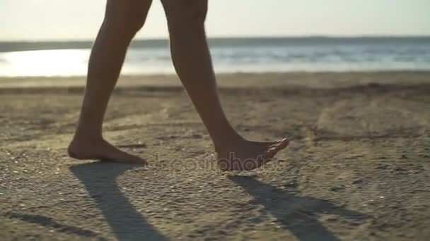 Close-up van de mens benen lopen zand strand zee zonsopgang snelle langzame motie — Stockvideo