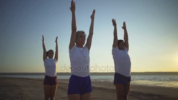 Gruppo di persone pratica yoga posa namaste mare alba rapido rallentatore — Video Stock