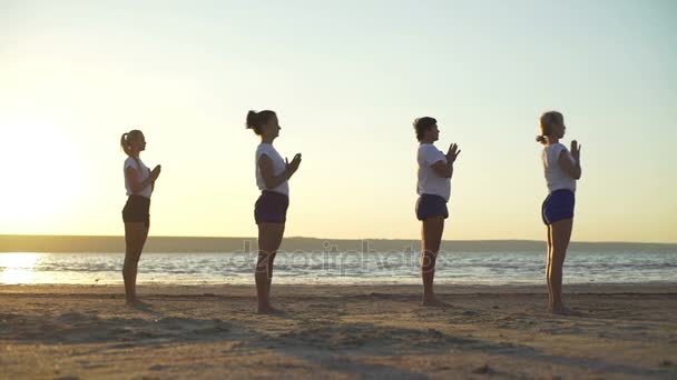 Groep mensen profile yoga namaste voorwaartse tilt pose zonsopgang snelle langzame motie — Stockvideo