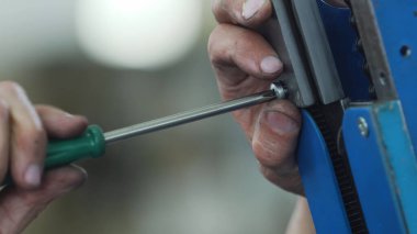 İşçi değirmen makinesinde anahtar ile bölümü vidaladı 