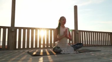 Kız Lotus 'ta oturur, derin derin meditasyon yapar çatıda gün ışığında.