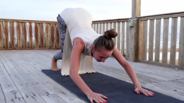 Unge hvite jenter øver på yoga på hustak ved en fargerik solnedgang – stockvideo