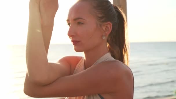 Крупним планом біла дівчина робить орел йога асана на даху на сході сонця — стокове відео
