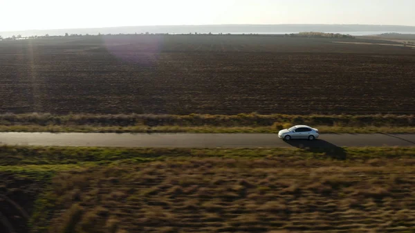 Hava manzaralı araba tarım sahalarından geçiyor güneşli sabah dronu