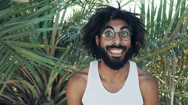 Retrato de homem negro rindo do lado de fora em pano de fundo de folhas de palma — Fotografia de Stock