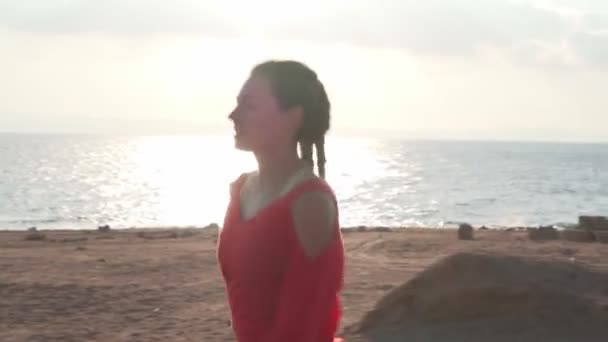 Atletisch Kaukasisch meisje loopt op de promenade bij zonsondergang in de buurt van de oceaan — Stockvideo