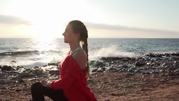 Mujer atlética haciendo un entrenamiento en la orilla del mar al atardecer — Vídeo de stock