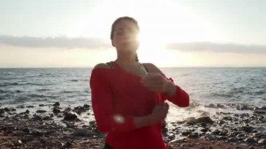 Deniz kıyısındaki kadın antrenmandan önce geriniyor.