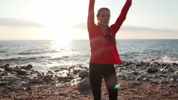 Donna sulla riva del mare riscaldamento prima dell'allenamento vista tramonto — Video Stock