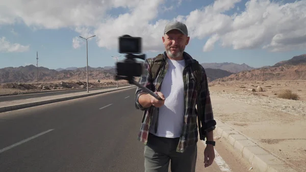 Yürüyen gezgin erkek monopod ile kendini vuruyor.