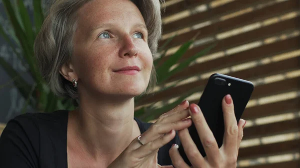 Nahaufnahme attraktive graue Haare Dame mit Smartphone in Café — Stockfoto