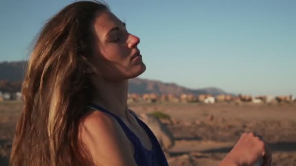 Sportliches Mädchen setzt Mütze auf den Kopf in der Natur bei Sonnenuntergang in Zeitlupe — Stockvideo