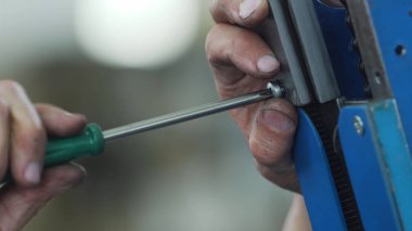 İşçi değirmen makinesinde anahtar ile bölümü vidaladı