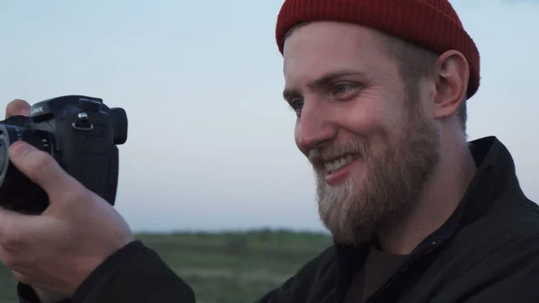 Счастливый хипстер оператор видео снимает на природе на закате — стоковое фото