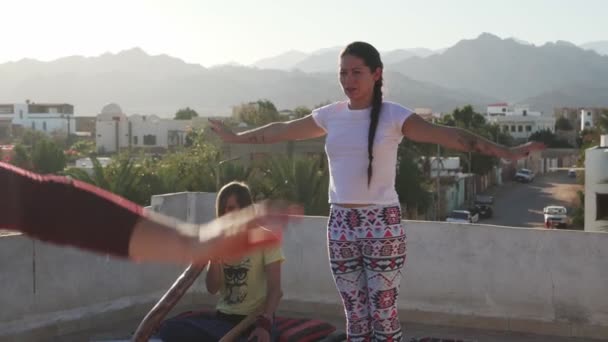 Professeur de yoga former des gens tout en homme jouant instrument didgeridoo sur le toit — Video