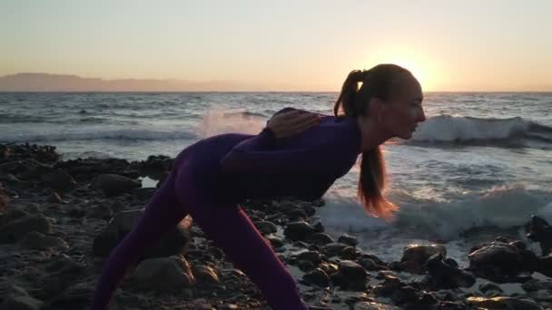 Flexível branco menina prática ioga pose na praia da manhã — Vídeo de Stock