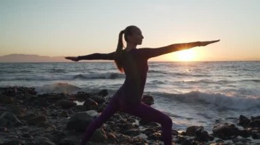 Esnek Kafkasyalı kız sabah deniz kıyısında yoga üçgeni.