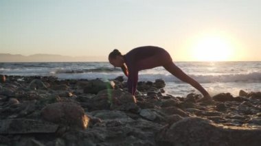 Gün batımında yoga yapan esnek beyaz kadın.