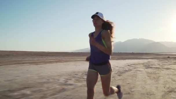 Pohled na mladé motivované dívky jogging v suché poušti při východu slunce — Stock video