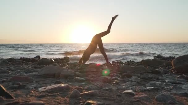 Flexibilní běloška dívka cvičit jógu při západu slunce pobřeží — Stock video