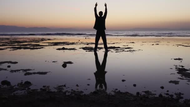 Människan övar qigong övningar, grunt vatten reflekterande figur — Stockvideo