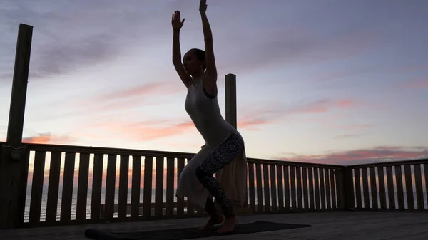 Joven chica caucásica practicar yoga en la azotea en la puesta de sol de colores brillantes . —  Fotos de Stock