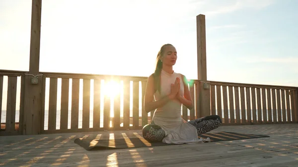 Chica se sienta en la pose de loto profundamente meditando en la azotea bajo el sol . —  Fotos de Stock