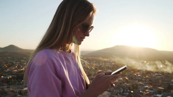 Attraente giovane femmina utilizzando il suo smartphone con backgroung città antica — Foto Stock