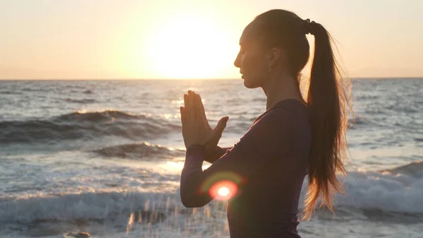 Vista lateral de una joven caucásica practicando yoga al atardecer . —  Fotos de Stock